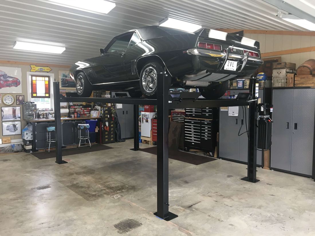 Classic Camaro raised on a Challenger Home Storage lift in a home garage